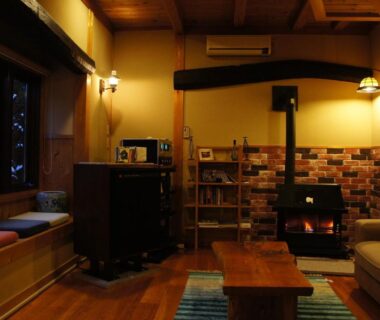 Interior lounge with wood-burning stove, low table and window seat at Hanaya Tokubei, Nara
