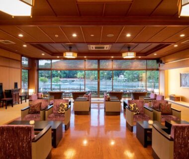 Traditional lounge with low tables and garden view at Hanayashiki Ukifune-en, Kyoto