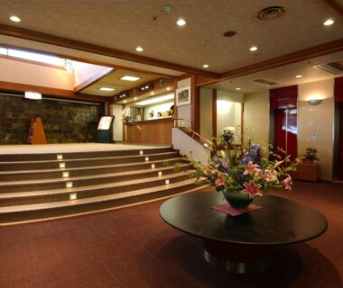 Carpeted lobby with central flower arrangement, staircase and elevators, Harataki, Fukushima Tōhoku