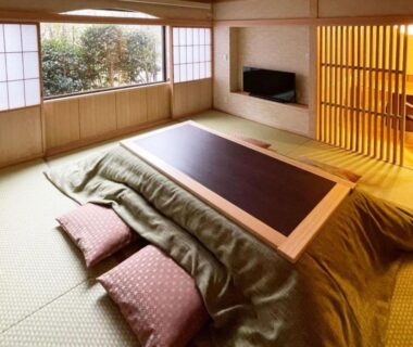 Traditional tatami room with kotatsu, floor cushions, shoji screens and garden view at Harumiya Ryokan, Fukushima