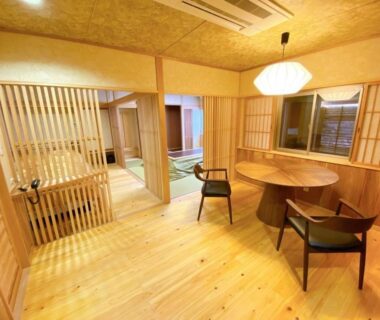 Warm wooden interior with round table, shoji screens and seating at Harumiya Ryokan in Fukushima Tōhoku