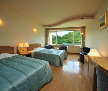 Twin beds with large window showing green hillside at Harunako Onsen Yusuge, Gunma, Kantō