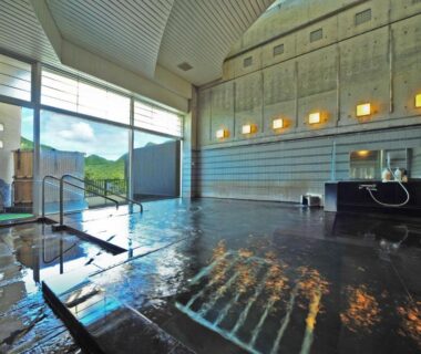 Spacious indoor onsen with stone floor and wooden baths at Harunako Onsen Yusuge, Gunma, Japan
