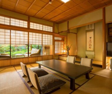 Traditional tatami room with low table, zabuton seating, shoji screens and garden view at Hashinoya Bekkan Ransui Hyōgo