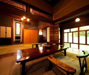 Interior tatami room with low wooden table, bench seating and shoji windows at Hatago Kayausagi in Oita Kyushu