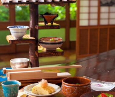 Assorted traditional Japanese dishes on low table in tatami room with shoji screens at Hatago Kayausagi, Ōita