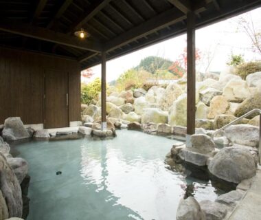 Covered rock onsen bath with stone edging at Hatago Sakura in Ōita Kyūshū