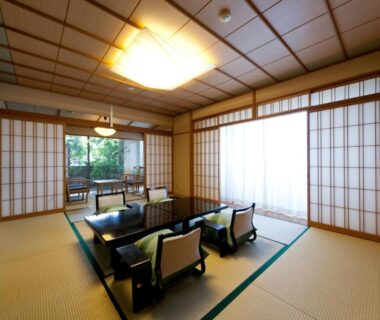 Low table and seating on tatami with shoji screens overlooking garden at Hatori in Chūbu, Ishikawa