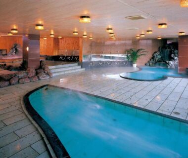 Spacious indoor onsen pools with tiled deck and lounge seating at Hatoya Hotel in Shizuoka, Chūbu Japan