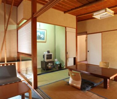 Traditional tatami room with low wooden table, shoji screens, tokonoma alcove and floor seating at Hatsunoyu in Nagano Chubu