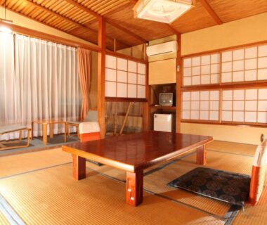 Traditional tatami room at Hatsunoyu with low table, zabuton cushions and shoji screens in Nagano