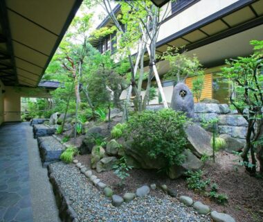 Traditional ryokan courtyard with stone garden, gravel path and wooden corridors at Hayamakan in Yamagata