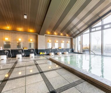 Indoor onsen bath with washing stations and large windows at Healthy Pal Akagi in Gunma, Kantō