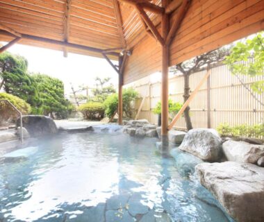 Covered rock-lined onsen bath with wooden roof at Heiseikan Shiosaitei, Hokkaidō