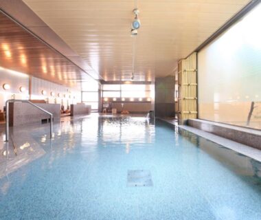 Spacious indoor bath with tiled floor and large windows at Heiseikan Shiosaitei Hokkaidō Japan