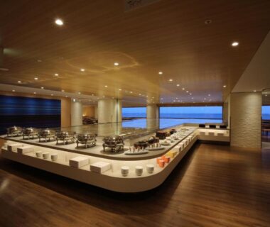 Long buffet counter and seating with wooden floors and large windows at Heiseikan Shiosaitei, Hokkaidō