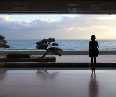 Silhouette by large window overlooking the sea from ryokan lobby at Heiseikan Shiosaitei, Hokkaidō