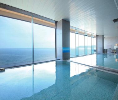 Indoor onsen bath with floor-to-ceiling windows overlooking the sea at Heiseikan Shiosaitei Hanatsuki Hokkaidō