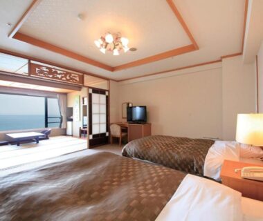 Twin beds, tatami seating and coastal view at Heiseikan Shiosaitei Hanatsuki, Hokkaidō