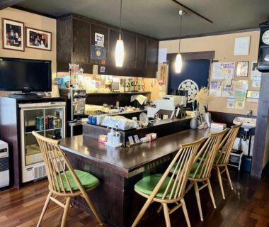 Wooden counter seating with pendant lights and chairs at Henmi Ryokan in Hokkaidō