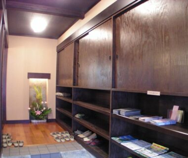 Traditional genkan with wooden shelves and slippers at Henmi Ryokan in Hokkaidō
