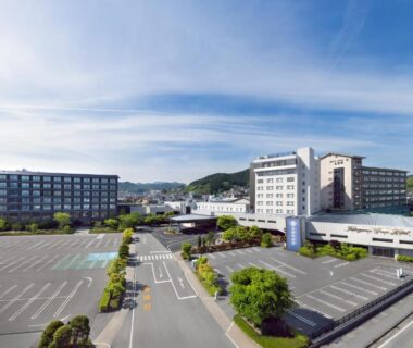 Wide exterior view of hotel buildings and parking lot at Hida Takayama Green Hotel, Gifu prefecture, Chūbu Japan