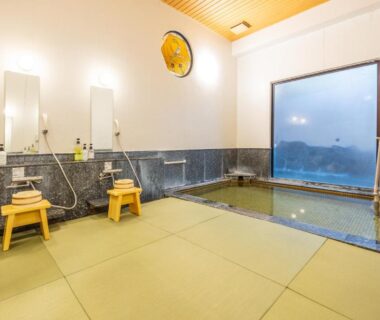 Indoor onsen bath with tatami flooring, wooden stools and tiled pool at Hidamari Ichinoyu in Kanagawa, Kantō