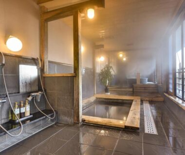 Steaming indoor wooden bath with washing stations at Hidatakayama Futarishizuka Hakuun in Gifu