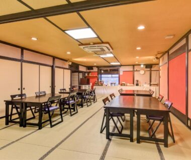 Tatami dining hall with low tables, chairs and shoji screens at Hidatakayama Futarishizuka Hakuun in Gifu