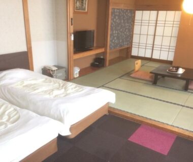 Tatami seating area with low table, shoji screens and twin beds at Higashiyama Park Hotel Shinfugetsu, Fukushima
