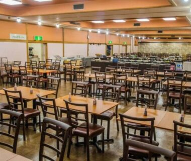 Large dining room with wooden tables and chairs at Higashiyama Park Hotel Shinfugetsu, Fukushima
