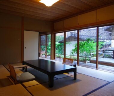 Tatami mats, low table and zaisu chairs facing a courtyard garden through sliding doors at Hiiragiya, Kyoto