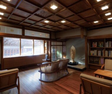 Spacious wooden lounge with coffered ceiling, sofa seating, bookshelf and large lattice windows at Hiiragiya, Kyoto