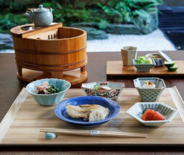 Wooden tray with assorted small dishes, teapot, and side servings in a ryokan dining setting at Hiiragiya Kyoto