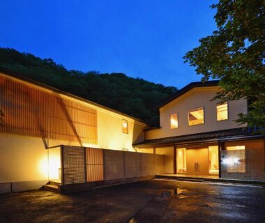 Exterior entrance with wooden lattice and warm lighting at Hinatamikan in Gunma, Kantō