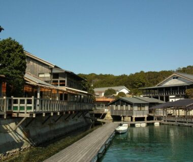 Wooden ryokan buildings and boardwalk along calm waterfront at Hiogiso in Mie, Kansai
