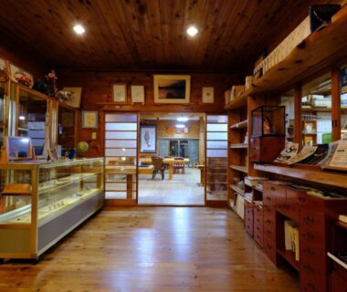Wooden reception area with glass display case and shoji screens at Hiogiso ryokan in Mie