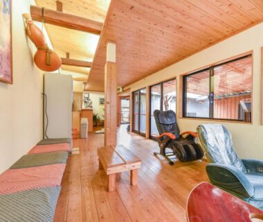 Long wooden lounge with massage chairs and bench seating at Hirayama Onsen Ryokan Kadoya in Kumamoto, Kyushu