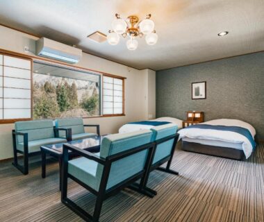 Beds, shoji screens and seating with hill view at Hirayukan, Chūbu, Gifu, Japan