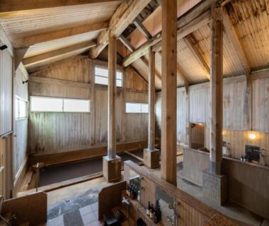 High wooden onsen bathhouse interior with timber beams and multiple bathing pools at Hirayukan in Gifu, Chubu