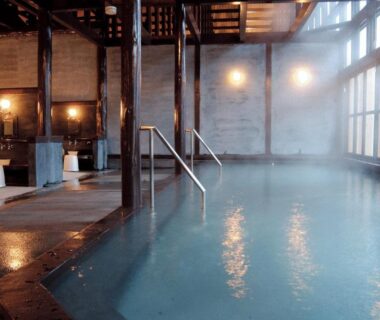 Steamy indoor onsen bath with wooden pillars and large windows at Hirayunomori, Gifu, Chūbu Japan