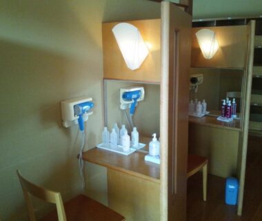 Wall-mounted hairdryers and toiletries on wooden vanity at Hirugami Grand Hotel Tenshin, Nagano, Chūbu