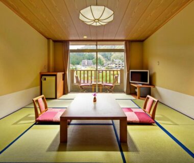 Tatami room with low table, floor cushions and balcony view at Hirugami Grand Hotel Tenshin, Nagano