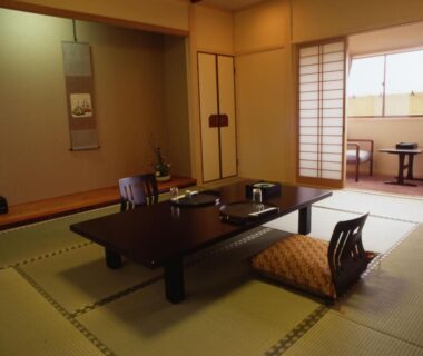 Traditional tatami room with low table, zabuton cushions, shoji screens and tokonoma alcove at Hitomaru Kadan in Hyōgo