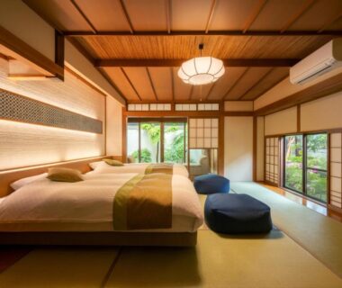 Traditional tatami room with twin beds, shoji screens and garden view at Hohoemino Kuyufu Tsuruya, Yamagata