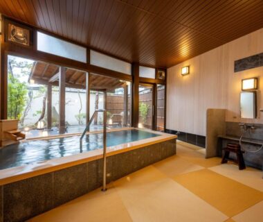 Indoor tiled onsen bath with handrail and wooden ceiling at Hohoemino Kuyufu Tsuruya, Yamagata Tōhoku