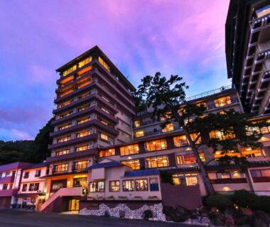 Multi-story ryokan lit at dusk with warm windows, Hokkawa Onsen Hotel, Shizuoka, Chūbu, Japan