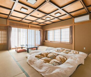 Tatami room with futon bedding, shoji screens, low table and wooden ceiling at Hokkawa Onsen Hotel, Shizuoka