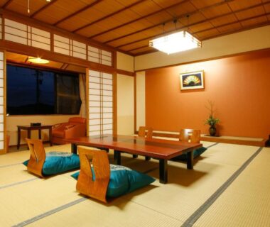 Traditional tatami room with low wooden table, zabuton cushions and shoji screens at Hokuriku Yamashiro Onsen Hotel Kikyou in Ishikawa