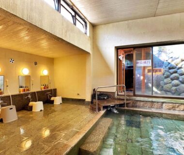 Indoor stone onsen with washing stations and stools at Honjin ryokan in Shizuoka, Chūbu, Japan